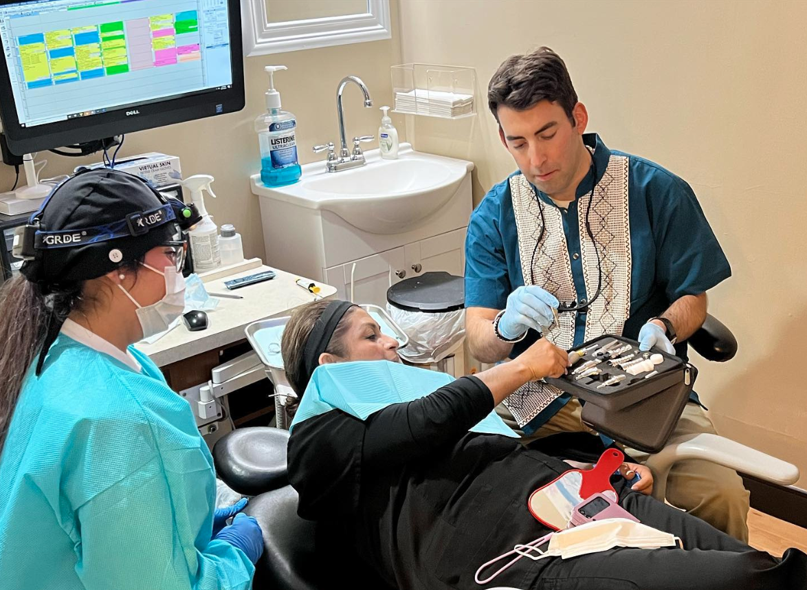 Dr. Alex Einbinder works with his staff on a dentistry patient at their West Babylon, NY office