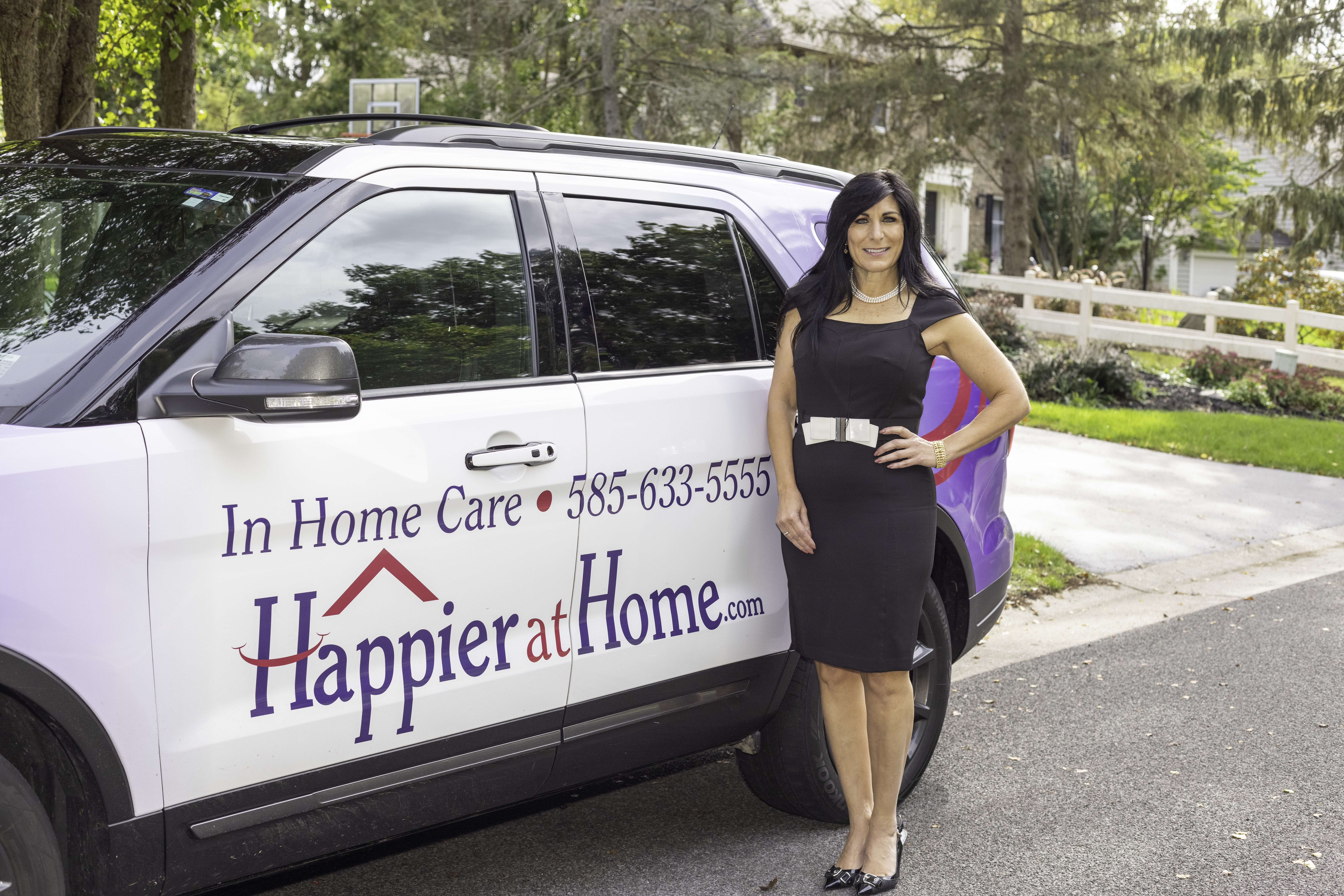 Founder Debbie Marcello stands next to a Happier at Home team vehicle