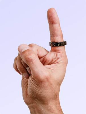 Hand with the glossy black Happy Ring on the index finger.